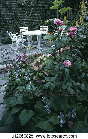 Stock Photography - Furniture on patio in town garden in summer. Fotosearch