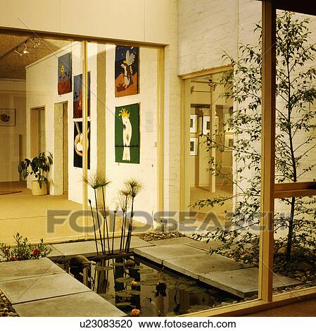 Glass doors open onto small rectangular pool in atrium in modern hall View Large Photo Image Stock Image - Glass doors open onto small rectangular pool in atrium in modern hall. Fotosearch
