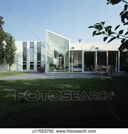Stock Image - Glass extension on modern white house in the country. Fotosearch