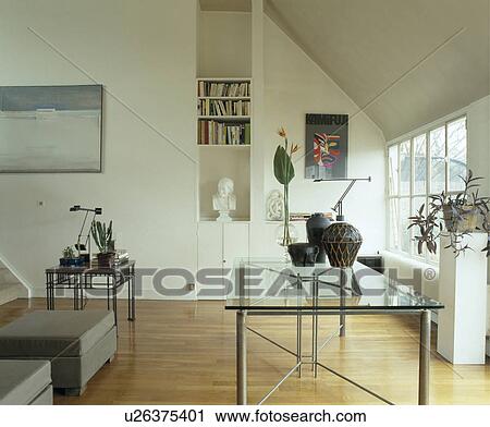Glass-topped table and wooden flooring in modern white living room View Large Photo Image Stock Image - Glass-topped table and wooden flooring in modern white living room. Fotosearch