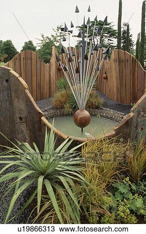 Grasses in front of circular wooden fence enclosing pond with modern sculpture View Large Photo Image Stock Image - Grasses in front of circular wooden fence enclosing pond with modern sculpture. Fotosearch