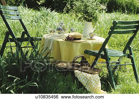 Green chairs and yellow cloth on table in long grass View Large Photo Image Stock Photograph - Green chairs and yellow cloth on table in long grass. Fotosearch