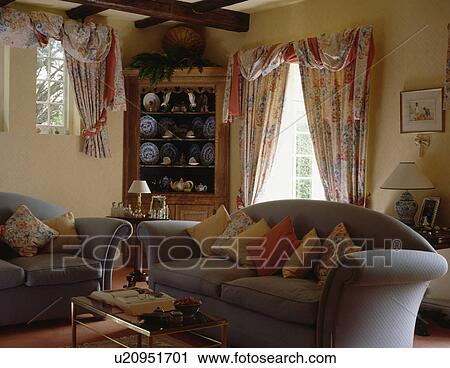 Grey sofa and floral curtains in cottage living room View Large Photo Image Stock Image - Grey sofa and floral curtains in cottage living room. Fotosearch