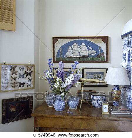 Group of pictures on wall above blue+white jugs on table View Large Photo Image Stock Photograph - Group of pictures on wall above blue+white jugs on table. Fotosearch