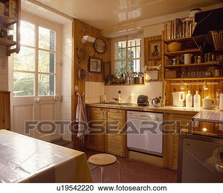 Half-glazed door in wooden kitchen with track lighting above worktops View Large Photo Image Stock Image - Half-glazed door in wooden kitchen with track lighting above worktops. Fotosearch