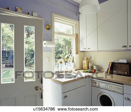 Half-glazed door open beside fitted cupboard with underset sink in mauve kitchen with fitted white cupboards View Large Photo Image Stock Photograph - Half-glazed door open beside fitted cupboard with underset sink in mauve kitchen with fitted white cupboards. Fotosearch
