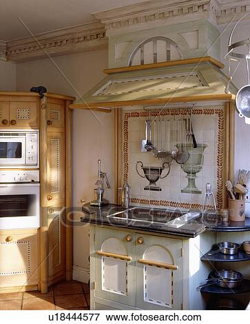 Stock Photo - Hob built into painted cupboard below decorative wall tiles . Fotosearch