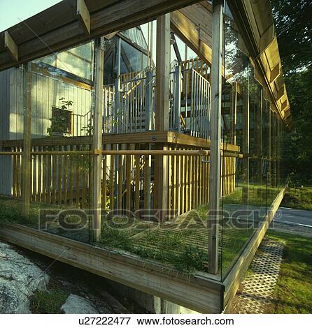 Stock Photo - Inside large ecological designed glass and wood conservatory. Fotosearch