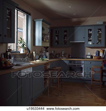 Picture - Integral dishwasher below window in blue traditional kitchen with wooden flooring. Fotosearch