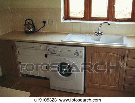 Kitchen With Washingmachine And Dishwasher Below Double White Sink