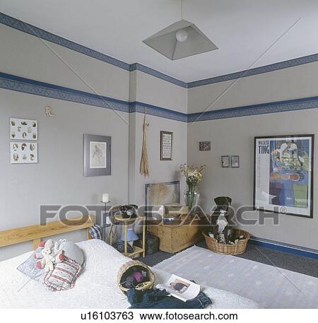 Knitting on bed and dog in basket in bedroom with blue wallpaper border and pine chest View Large Photo Image Stock Image - Knitting on bed and dog in basket in bedroom with blue wallpaper border and pine chest. Fotosearch