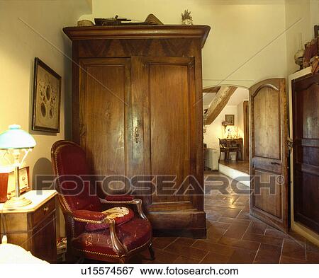 Large antique cupboard and leather armchair in country living room View Large Photo Image Stock Photo - Large antique cupboard and leather armchair in country living room . Fotosearch