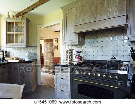 Large black oven in country kitchen with wooden cupboard doors and plate rack View Large Photo Image Stock Photo - Large black oven in country kitchen with wooden cupboard doors and plate rack. Fotosearch
