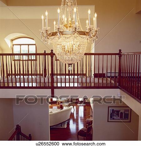 Large glass chandelier above modern landing with view of livingroom through open door View Large Photo Image Stock Image - Large glass chandelier above modern landing with view of livingroom through open door. Fotosearch