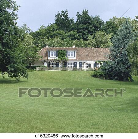 Stock Photograph - Large lawn in front of country house in summer. Fotosearch