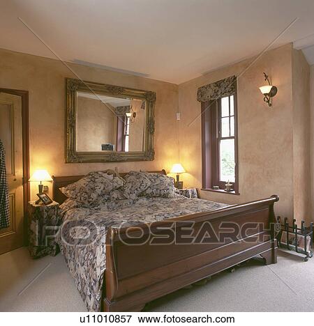 Picture Of Large Mirror Above Sleigh Bed In Bedroom With Marbled Large Mirror Above Sleigh Bed In Bedroom With Marbled Paint Effect On The Walls And Lighted Lamps Either Side Of