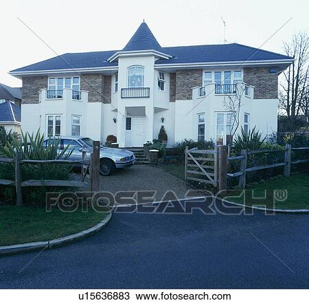 Stock Image - Large newbuild house with balconies and small tower over central porch. Fotosearch