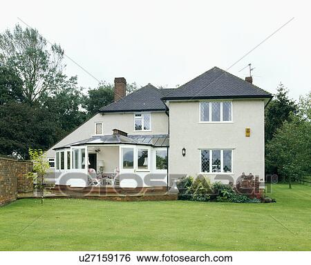 Stock Photograph - Large white fifties house with conservatory extension. Fotosearch