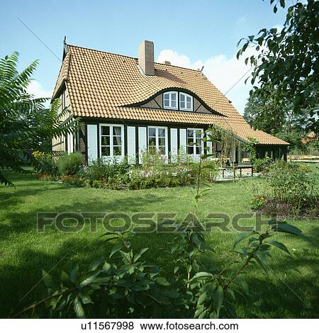 Stock Photo - Lawn in front of single-storey country cottage with dormer window . Fotosearch