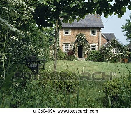 Picture - Lawn in front of traditional Victorian brick country cottage. Fotosearch