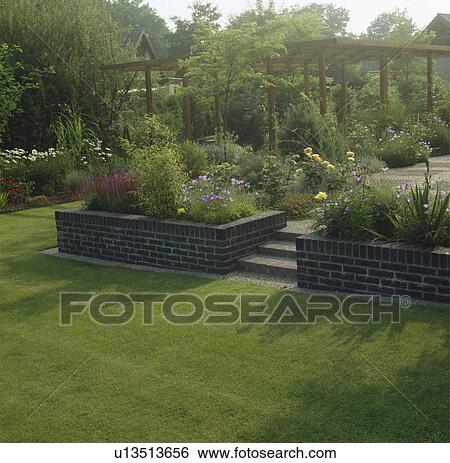 Lawn with steps to patio in summer country garden View Large Photo Image Stock Photograph - Lawn with steps to patio in summer country garden. Fotosearch