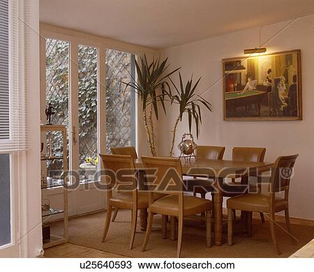 Light above picture in white dining room extension with French windows and forties table and chairs View Large Photo Image Stock Image - Light above picture in white dining room extension with French windows and forties table and chairs. Fotosearch