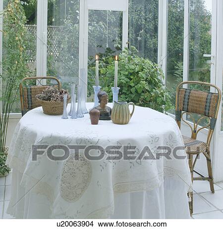 Lighted Candles And Ornaments On Circular Table With White Lace Cloth In Conservatory Dining Room With View Of Garden Picture U20063904 Fotosearch