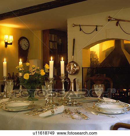 Lighted candles in silver candlesticks on table with white cloth and antique china with silver cutlery View Large Photo Image Stock Photo - Lighted candles in silver candlesticks on table with white cloth and antique china with silver cutlery. Fotosearch