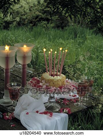 Lighted candles in tall glasses beside birthday cake with tall lighted candles in garden View Large Photo Image Stock Image - Lighted candles in tall glasses beside birthday cake with tall lighted candles in garden. Fotosearch