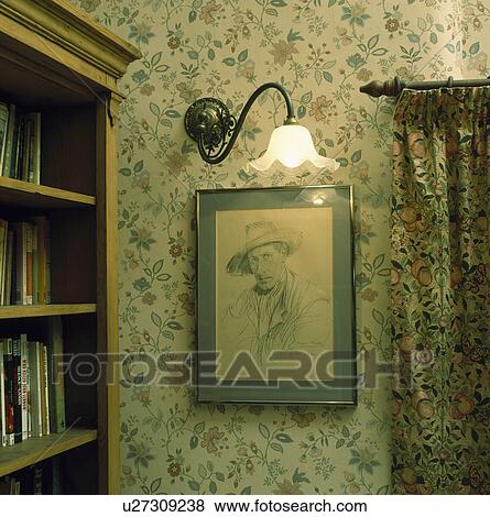 Lighted Edwardian brass wall light above framed drawing in corner of room with floral wallpaper View Large Photo Image Stock Photo - Lighted Edwardian brass wall light above framed drawing in corner of room with floral wallpaper. Fotosearch