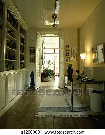 Lighted lamp on desk in narrow study with wooden floor View Large Photo Image Stock Image - Lighted lamp on desk in narrow study with wooden floor. Fotosearch