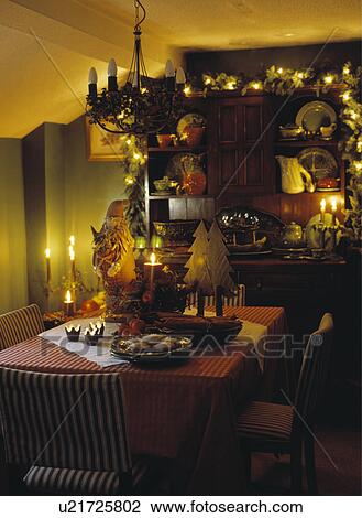 Lighting and garland on dresser in diningroom decorated for Christmas with small faux trees and candles on the table View Large Photo Image Stock Image - Lighting and garland on dresser in diningroom decorated for Christmas with small faux trees and candles on the table. Fotosearch