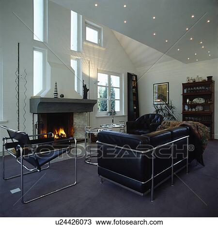 Stock Image - Marcel Breuer black Wassily chair and Le Corbusier black leather and chrome sofa in modern white living room. Fotosearch
