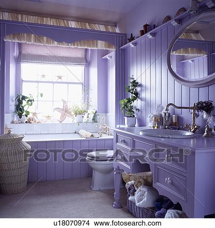 Picture - Mauve panelled bathroom with basin fitted into mauve painted chest of drawers. Fotosearch