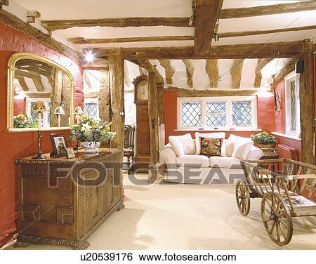 Mirror above carved wooden cupboard in red living room with cream carpet and wooden handcart View Large Photo Image Stock Photograph - Mirror above carved wooden cupboard in red living room with cream carpet and wooden handcart. Fotosearch