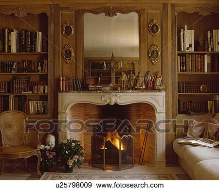 Mirror above fireplace with firescreen in traditional living room View Large Photo Image Stock Photo - Mirror above fireplace with firescreen in traditional living room. Fotosearch