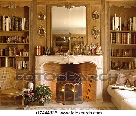 Mirror above fireplace with firescreen in traditional living room View Large Photo Image Stock Photograph - Mirror above fireplace with firescreen in traditional living room. Fotosearch