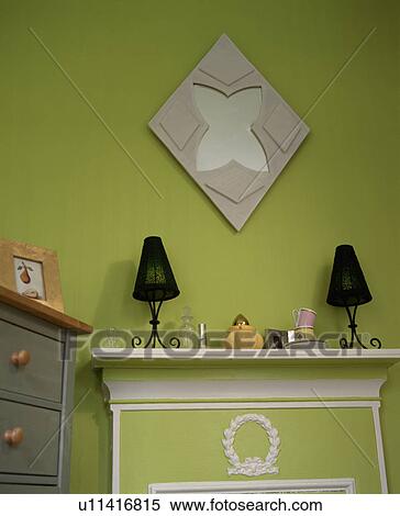 Mirror on green wall above black lamps on mantelpiece View Large Photo Image Stock Photography - Mirror on green wall above black lamps on mantelpiece. Fotosearch