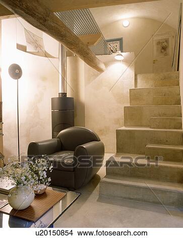 Picture - Modern black leather armchair beside staircase. Fotosearch