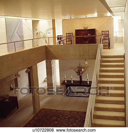 Stock Photo - Modern double height hall with gallery landing and cream stair carpet. Fotosearch