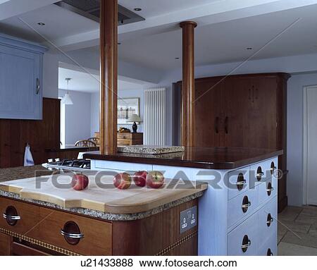 Modern white kitchen with contrasting wooden and white island units View Large Photo Image Stock Photo - Modern white kitchen with contrasting wooden and white island units. Fotosearch