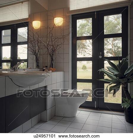 Modern white tiled bathroom with black glazed doors and white tiled floor View Large Photo Image Stock Image - Modern white tiled bathroom with black glazed doors and white tiled floor. Fotosearch