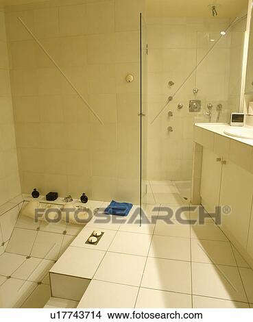 Picture - Modern white tiled wet room with a sunken jacuzzi bath . Fotosearch