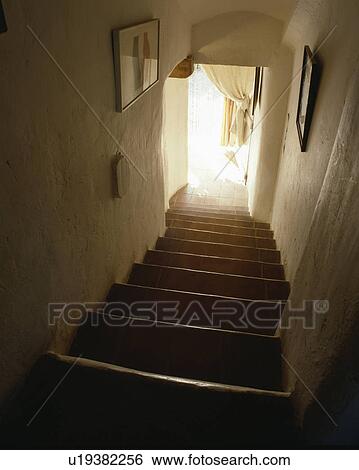 Stock Photograph - Narrow staircase with white walls and terracotta floor tiles. Fotosearch