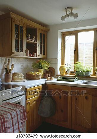 Stock Photo - Nineties fitted pine kitchen with white worktops. Fotosearch