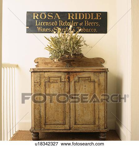 Old licensee sign above antive pine cupboard with dried flower arrangement View Large Photo Image Stock Photo - Old licensee sign above antive pine cupboard with dried flower arrangement. Fotosearch