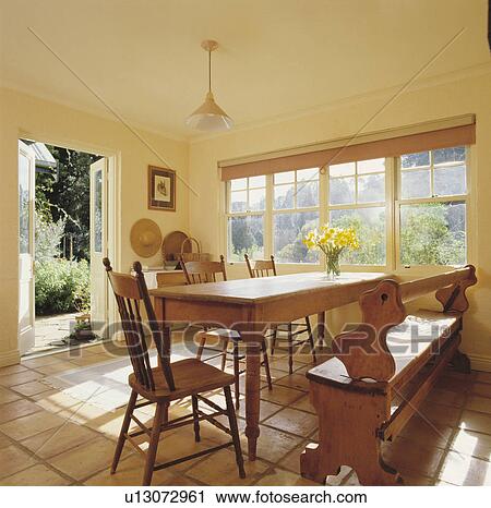 Old pine table and bench in cream dining room with terracotta tiled floor View Large Photo Image Stock Image - Old pine table and bench in cream dining room with terracotta tiled floor. Fotosearch