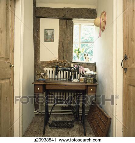 Old Singer sewing machine and table in corner of beamed cottage landing View Large Photo Image Stock Image - Old Singer sewing machine and table in corner of beamed cottage landing . Fotosearch
