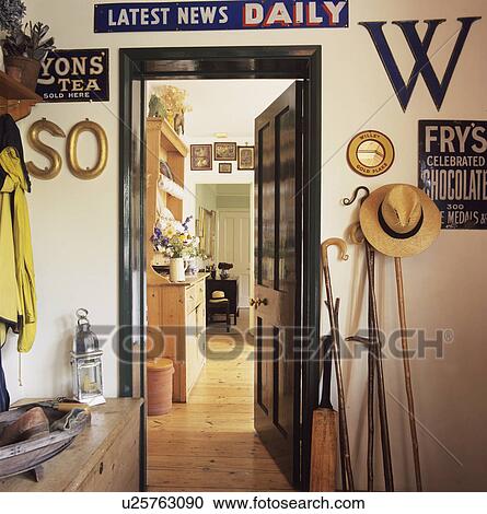 Stock Image - Old tin advertising signs and shepherds crooks above and beside doorway in small country hall. Fotosearch