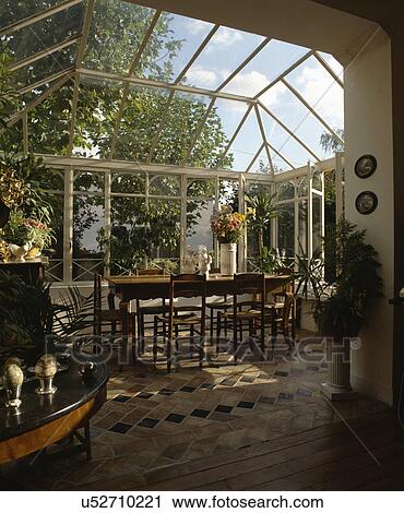 Old wood table and chairs on terracotta tiled floor in conservatory dining room View Large Photo Image Stock Image - Old wood table and chairs on terracotta tiled floor in conservatory dining room. Fotosearch